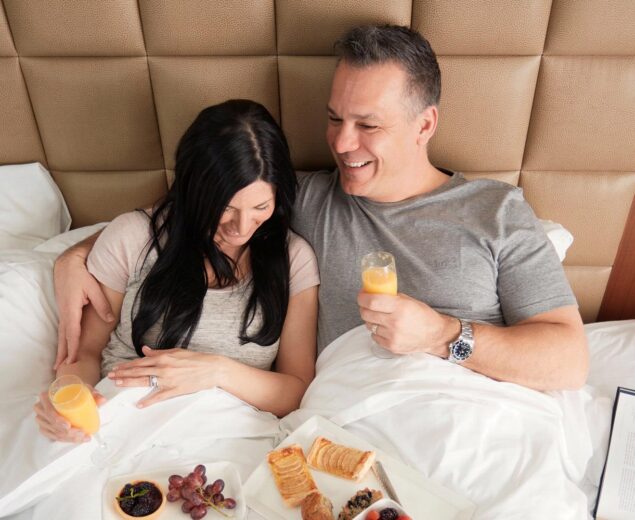 Couple in bed enjoying breakfast