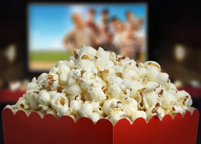 Red popcorn bucket in front of a movie screen during an outdoor movie night during Lansdowne's Virginia Spring Break programming.