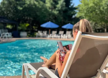 Woman reading magazine by the pool.