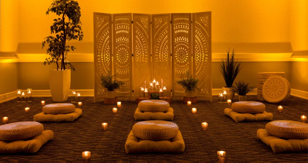 A serene meditation room showcasing candles and meditation pillows on the floor.